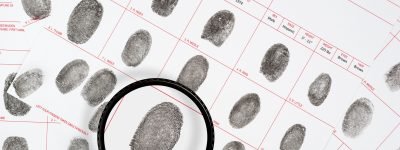 Fingerprints A forensic inspector looks at a suspect fingerprint on legal detective files.